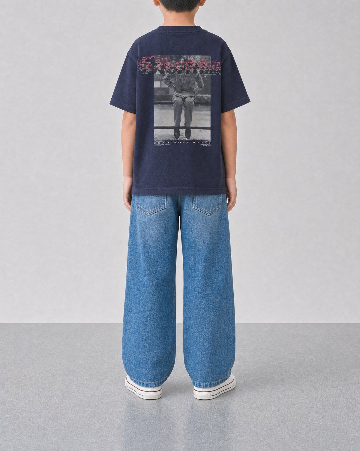 STORITIME® READ More Books Tee in Midnight Paradise, back on-body view with relaxed blue denim.