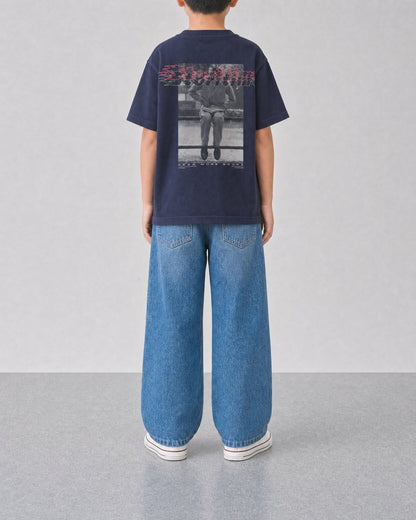 STORITIME® READ More Books Tee in Midnight Paradise, back on-body view with relaxed blue denim.